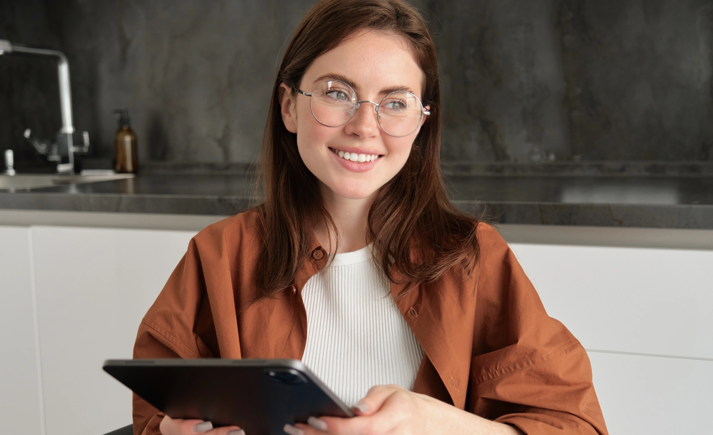 portrait young brunette woman holding digital tablet reading with glasses smiling 3